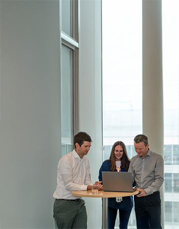 3 collega’s die naar een laptop kijken